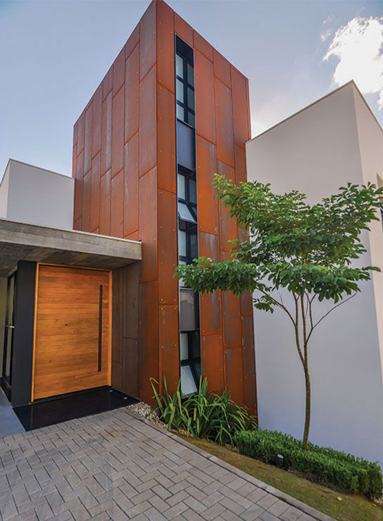 Projet contemporain illustrant l’intégration de Jardinières en acier Corten et d’un aménagement paysager autour d’une villa moderne.