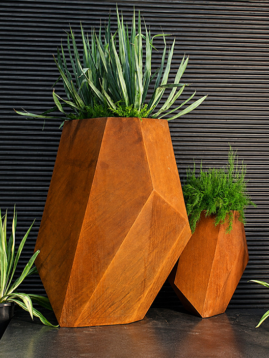 Jardinières en acier Corten géométriques avec plantes dans un aménagement contemporain
