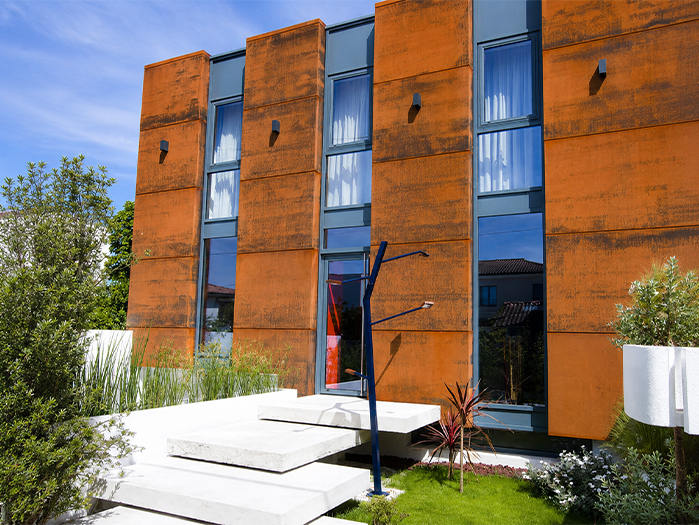 Ouvrages en acier Corten utilisés en bardage sur la façade d’un bâtiment contemporain